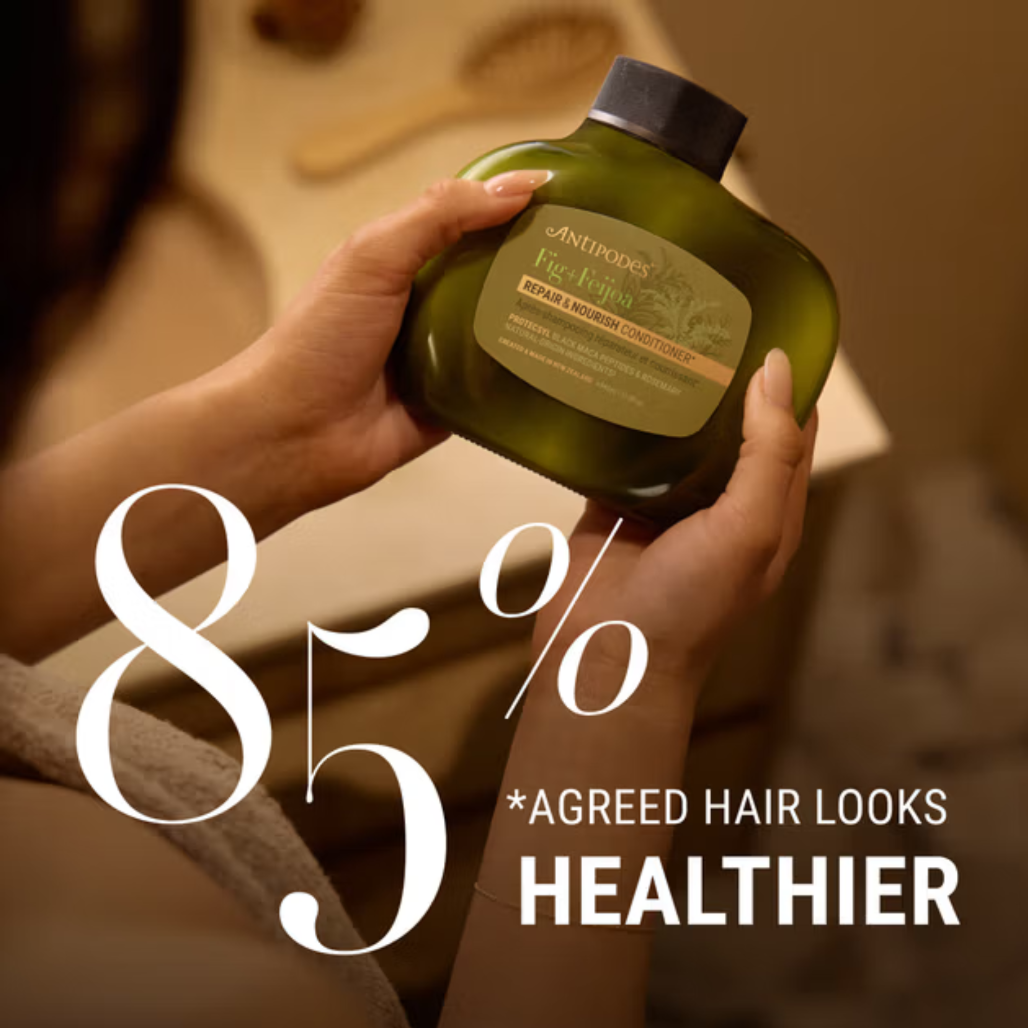 Hand holding a bottle of Antipodes Fig Feijoa Shampoos hair product with text about hair health.