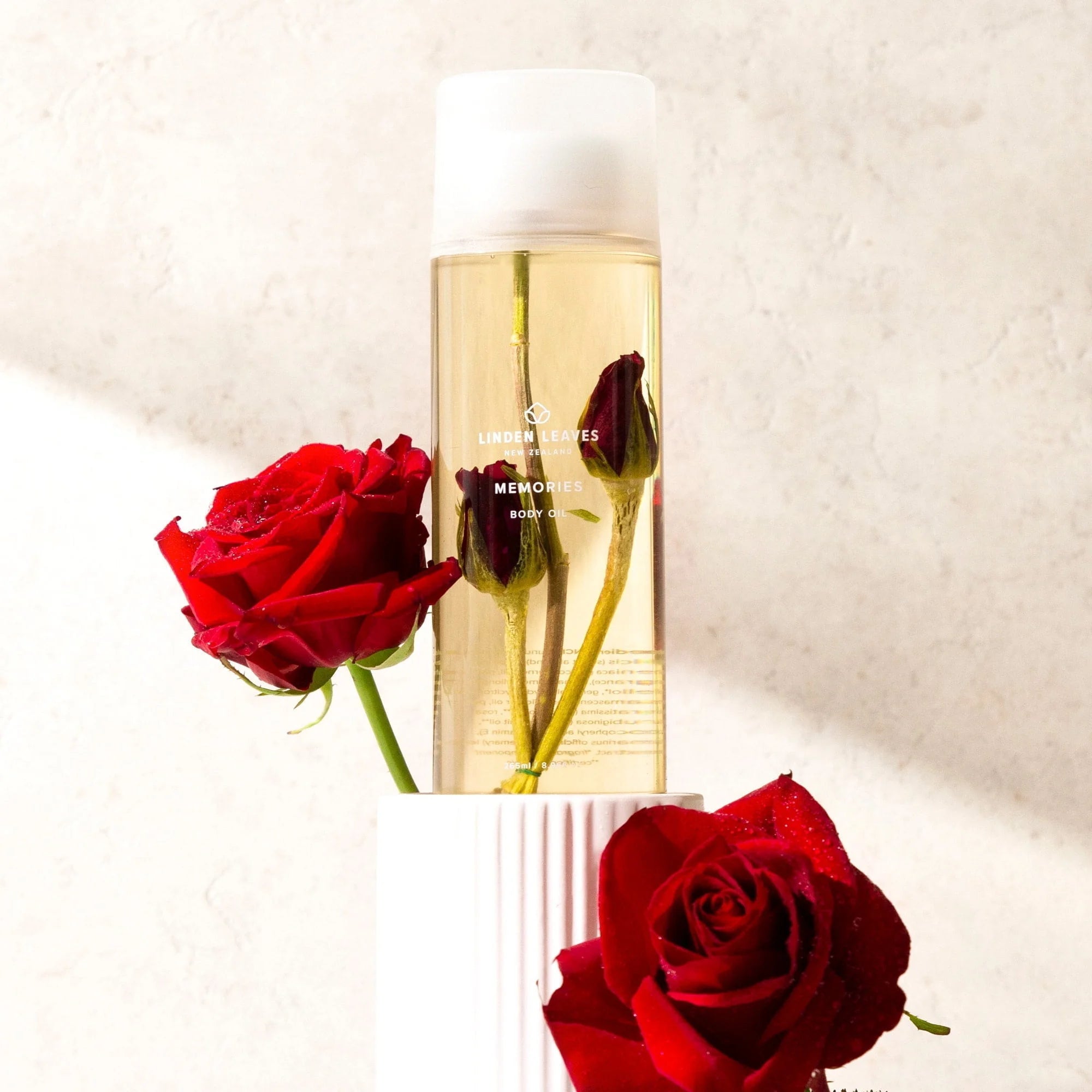 A bottle of Linden Leaves body oil Memories with two roses