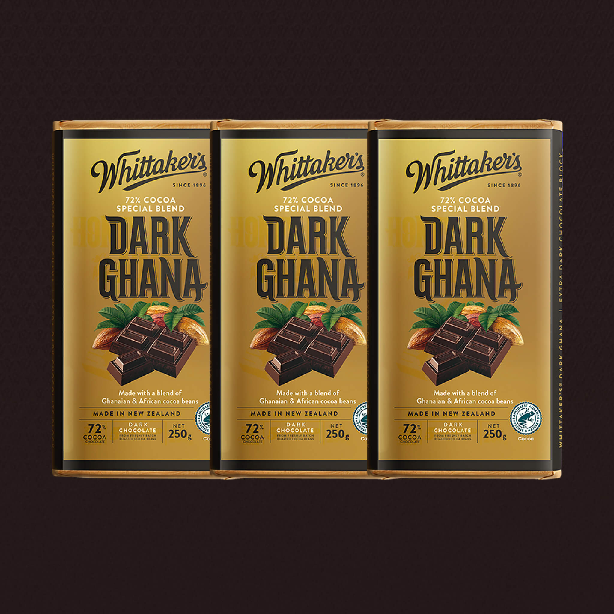Three packages of Whittaker's Dark Ghana chocolate on a dark background
