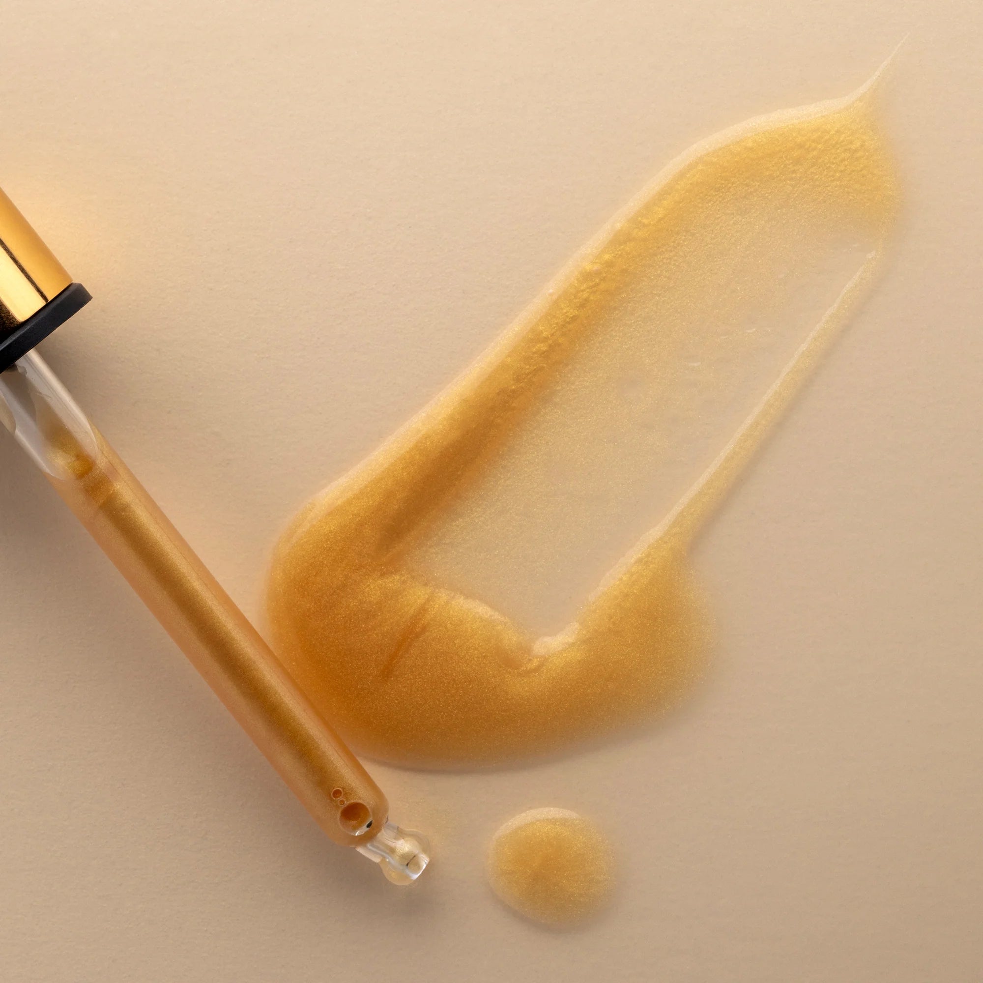 Cosmetic dropper with beige liquid of Antipodes Glow on a beige background