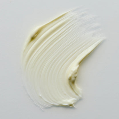 Close-up of a swatch of Antipodes Lime Cavier white cream on a light gray background