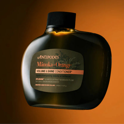 Antipodes Manuka Orange Volume & Shine Conditioner bottle on an orange background