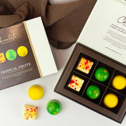 Assorted colorful chocolates in a box with a Chocolate Brown Branded chocolate packaging on a white surface.