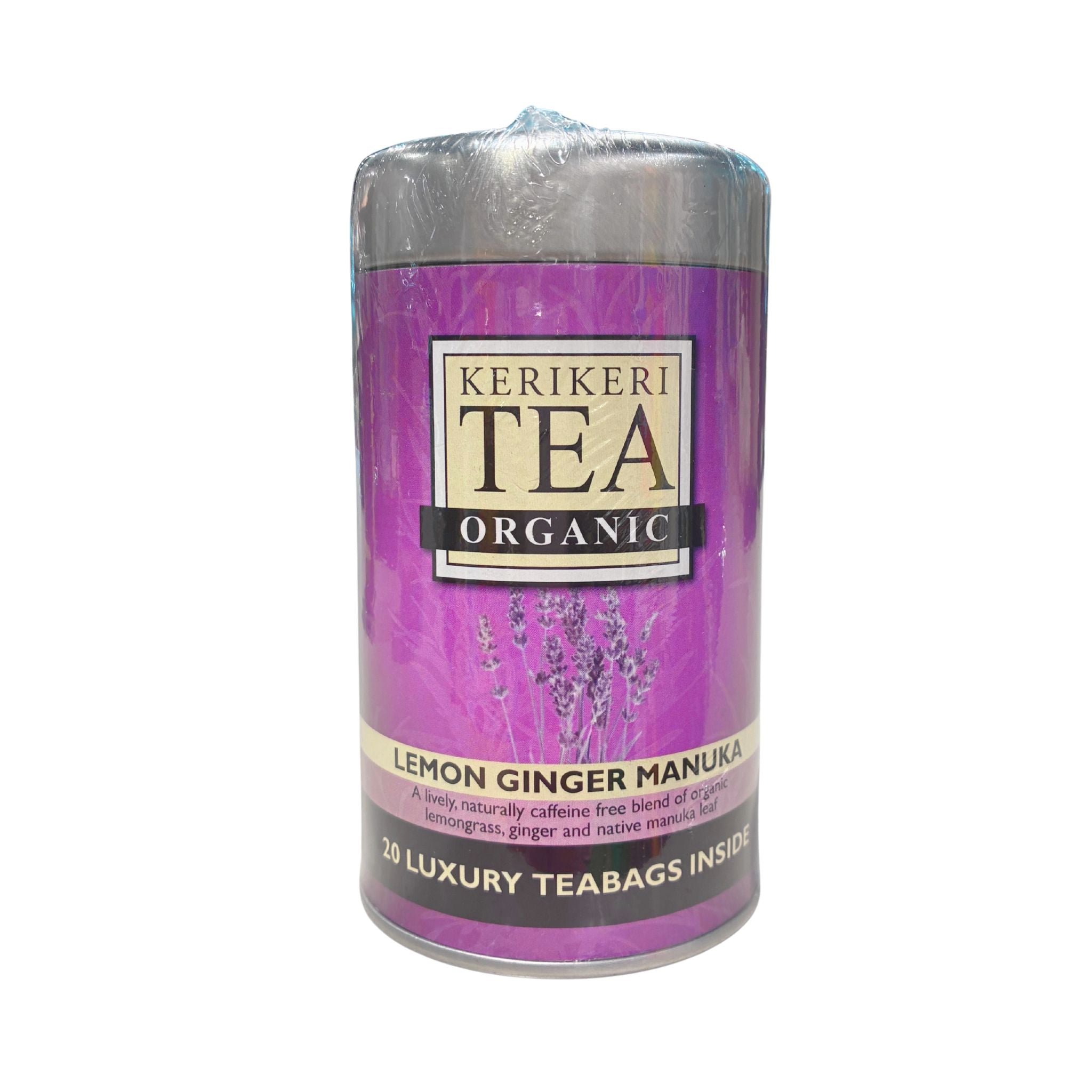 A cylindrical tea candle in clear plastic wrapping with a purple label reading 'KERIKERI TEA ORGANIC' and 'LEMON GINGER MANUKA'. The candle has a metallic silver top and bottom, and the label features purple lavender illustrations.