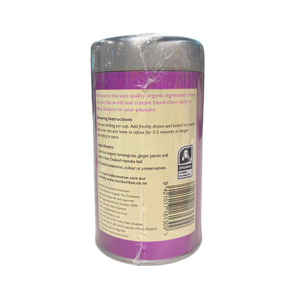 The back of a cylindrical glass bottle wrapped in clear plastic, showing a purple label with product information, a barcode, and a small A4 certification logo, on a white background.