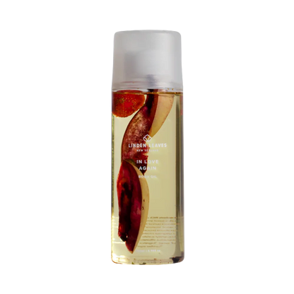 Bottle of Linden Leaves in love again  body oil with a white cap on a white background