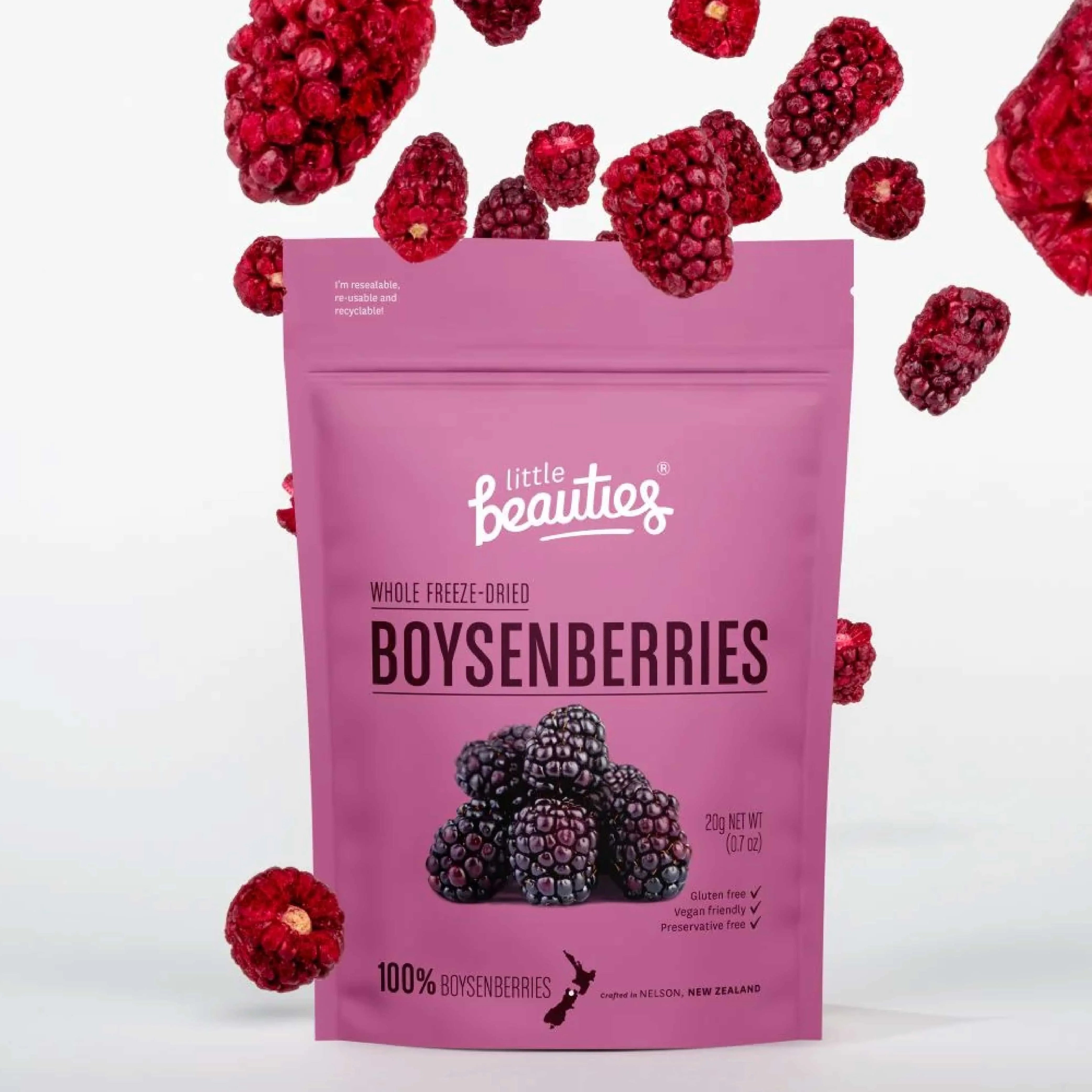 A bag of LIttle Beauties whole freeze dried boysenberries on a white background and the dried boysenberries outside the package.