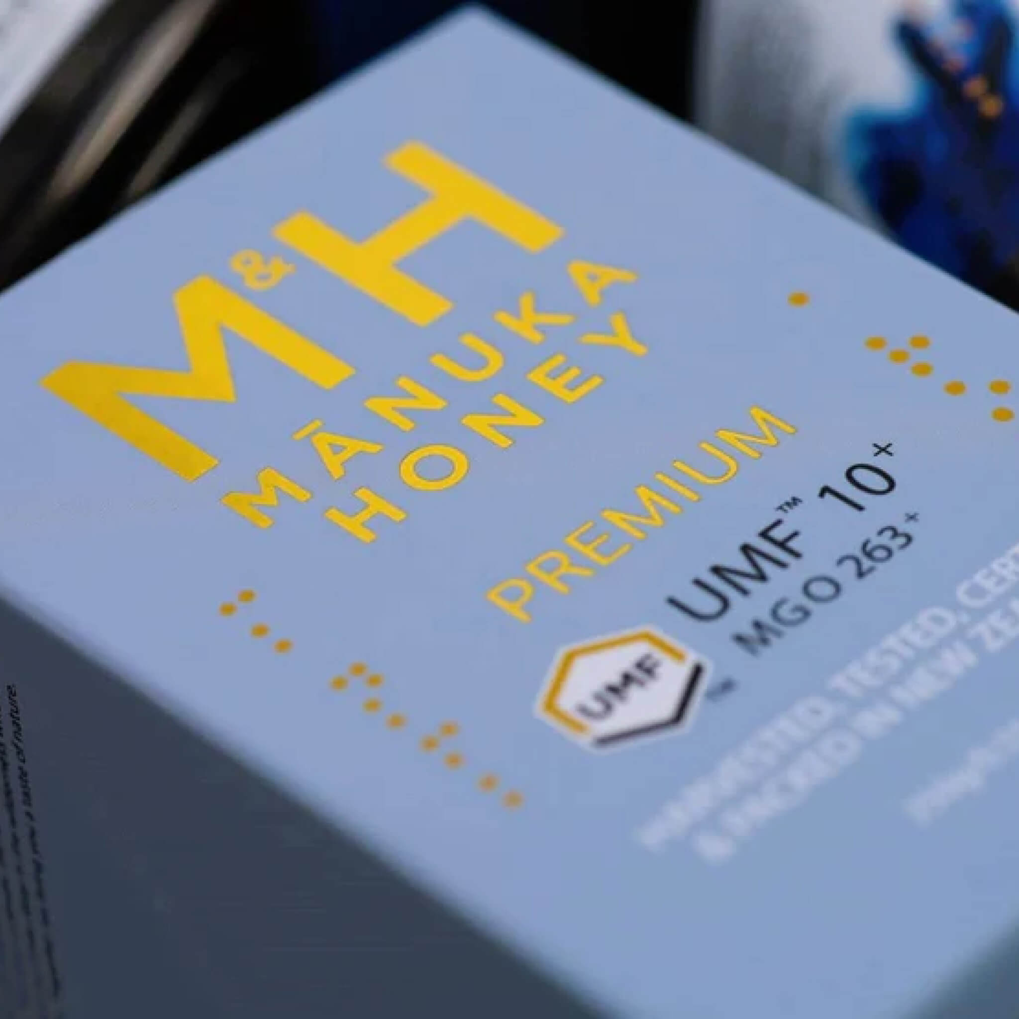 M&H Manuka Honey UMF 10+ package with yellow text on a blue background
