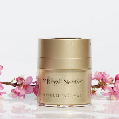 Gold jar of Royal Nectar premium face mask with pink flowers on a white background