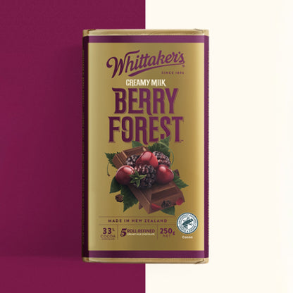 A single Whittaker's Creamy Milk Berry Forest chocolate bar in its packaging, shown against a split background of deep magenta and off-white.