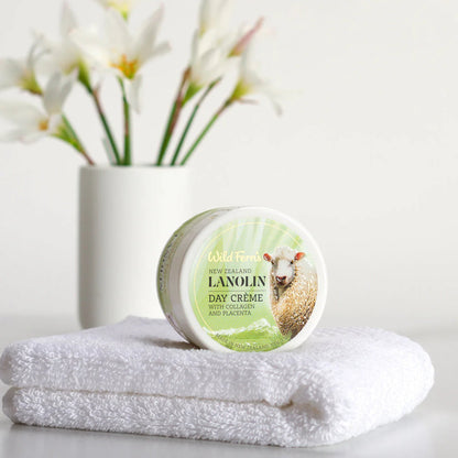 Jar of Wild Ferns lanolin day cream on a towel with flowers in the background