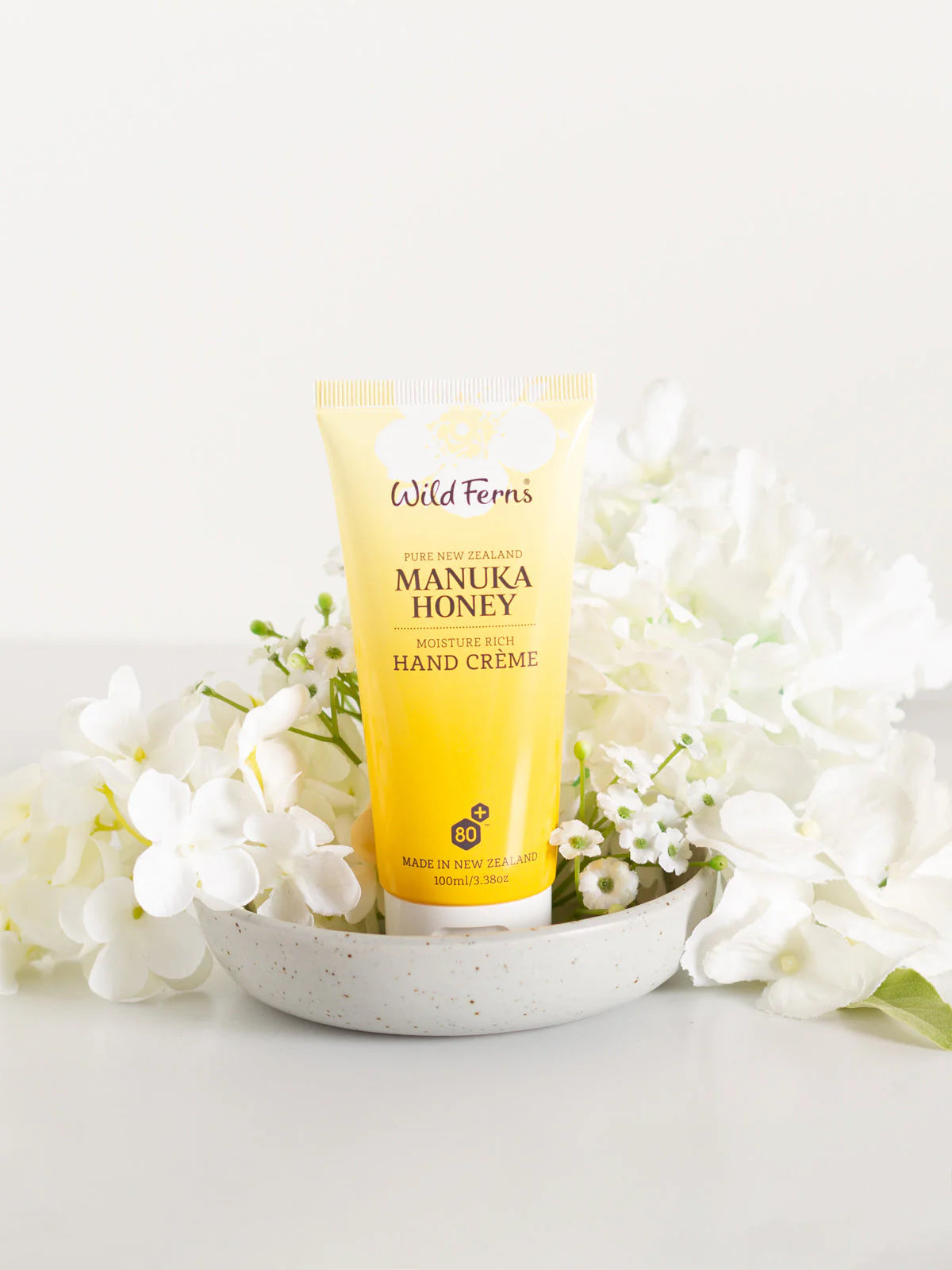 Wild Wern's manuka honey moisture rich hand cream on a white dish with flower