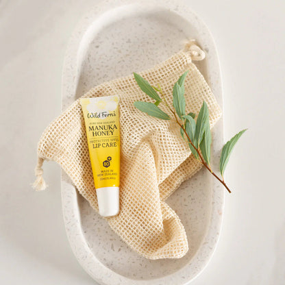 Wild Ferns Lip balm with 'Manuka Honey' on a textured stone surface