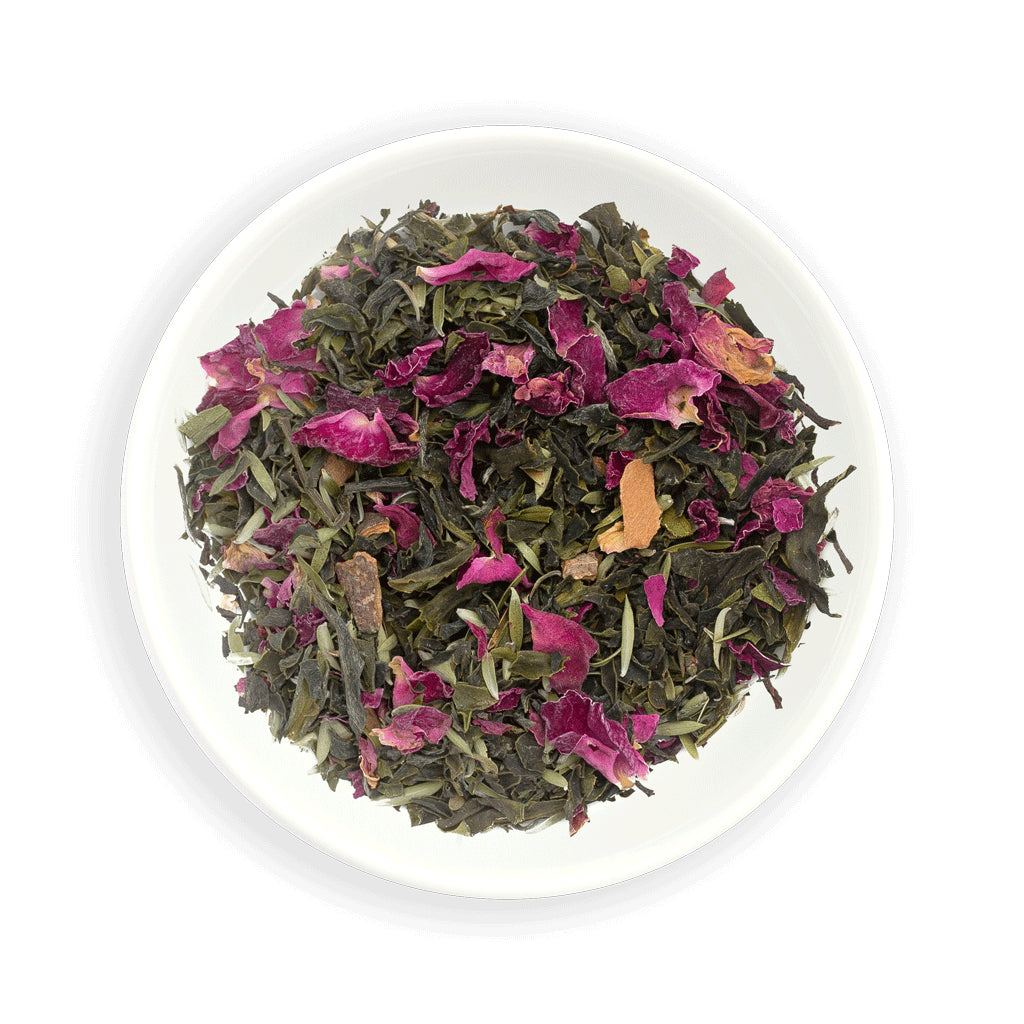 Zealong Tea leaves with pink petals and orange pieces on a white plate