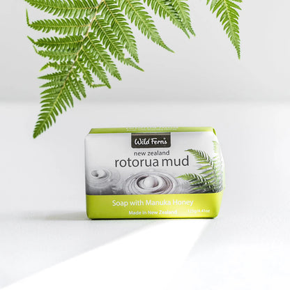 Soap bar with 'Rotorua Mud' packaging on a white background with green leaves.